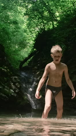 boy playing in a forest creek