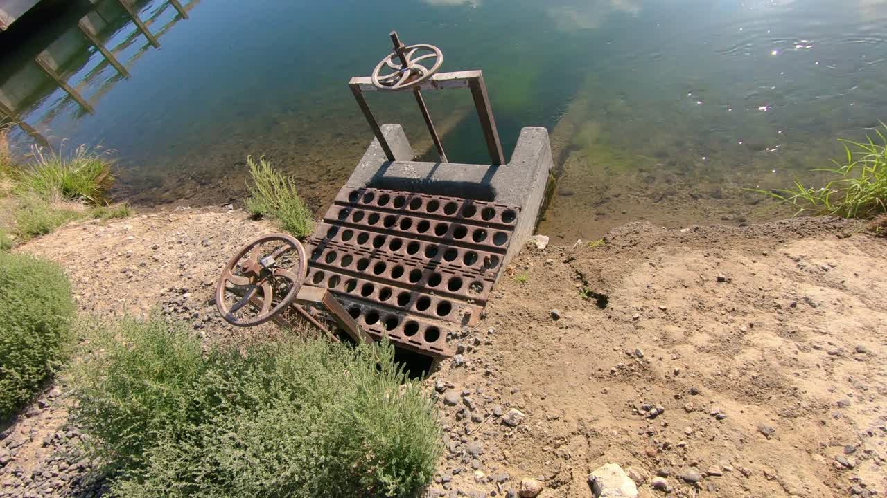 válvula de compuerta en un canal de riego con agua que fluye