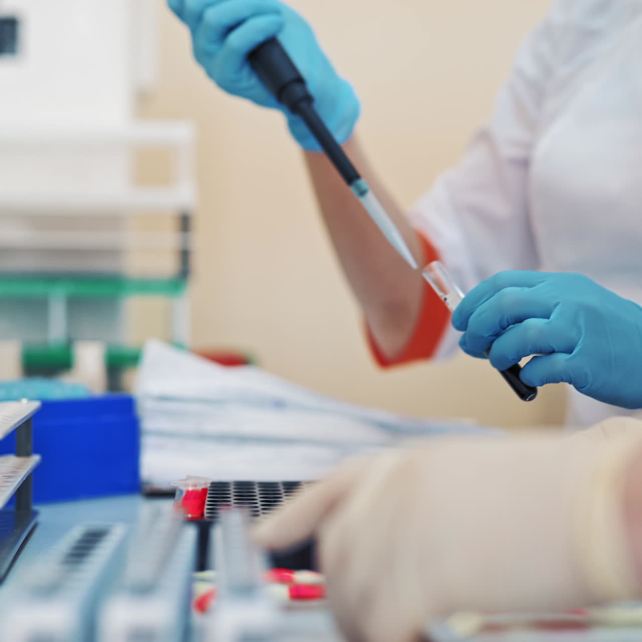 Professional laboratory technician fills vial with liquid and puts in the rack. Medical workers with test tubes of blood sample in the laboratory.