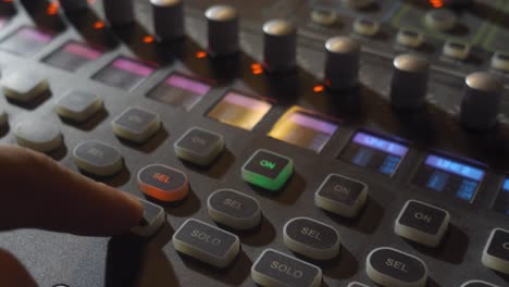 a person pressing a few buttons on a music mixer