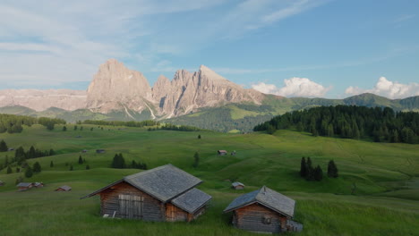 alpine huts, mountain inns on alpe di siusi, high altitude plateau in the dolomites alps at sunset, panoramic view, drone shot