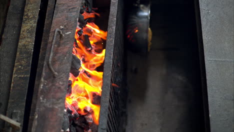 slow motion of red hot burning flaming charcoal in an old rusted restaurant grill