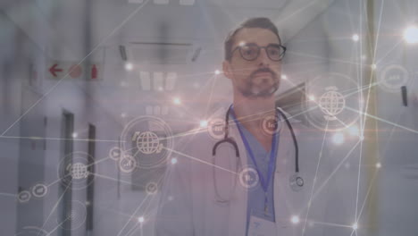 animation of network of connections with icons over caucasian male doctor at hospital