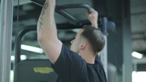 hombre haciendo pull-ups en el gimnasio
