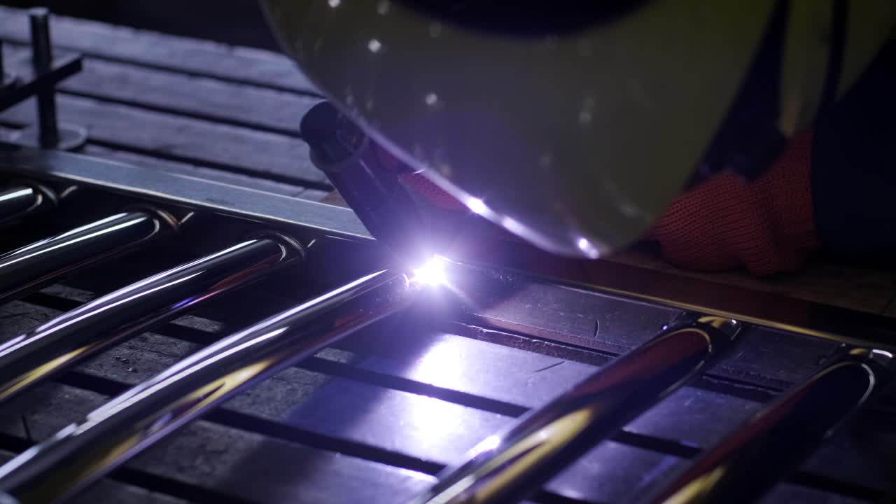 Man wearing mask welding in a workshop. Metal workers use manual labor. Skilled welder. Welder is welding the stainless steel pipes in the factory. welder Industrial part in factory.