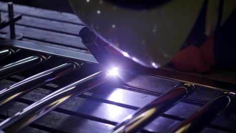 man wearing mask welding in a workshop. metal workers use manual labor. skilled welder. welder is welding the stainless steel pipes in the factory. welder industrial part in factory.