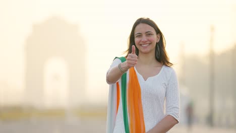 Happy-Indian-girl-showing-Thumbs-up-near-India-gate-Delhi-in-an-Indian-outfit