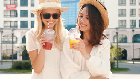 two happy women enjoying drinks outdoors