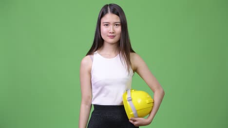 young beautiful asian businesswoman as engineer giving handshake