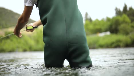 shot of a male fisherman wearing waders while fly fishing