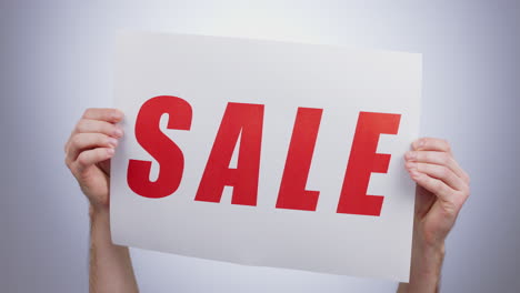 sale, sign and hands with a poster