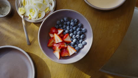 Fruit-bowl-sitting-on-a-wooden-table-next-to-freshly-cut-hardboiled-eggs