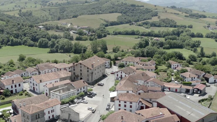 Vista aerea del pittoresco villaggio di Ospitalea immerso tra verdi colline ondulate, Irissarry, Francia.