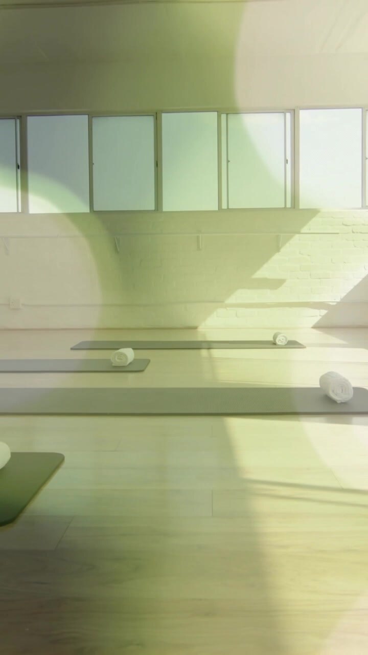 Tappetini da yoga e asciugamani arrotolati in studio con animazione bokeh verde