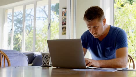 Man-using-laptop-at-home-4k