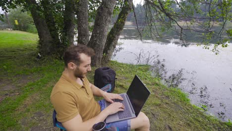 freelance businessman working on laptop in nature park.