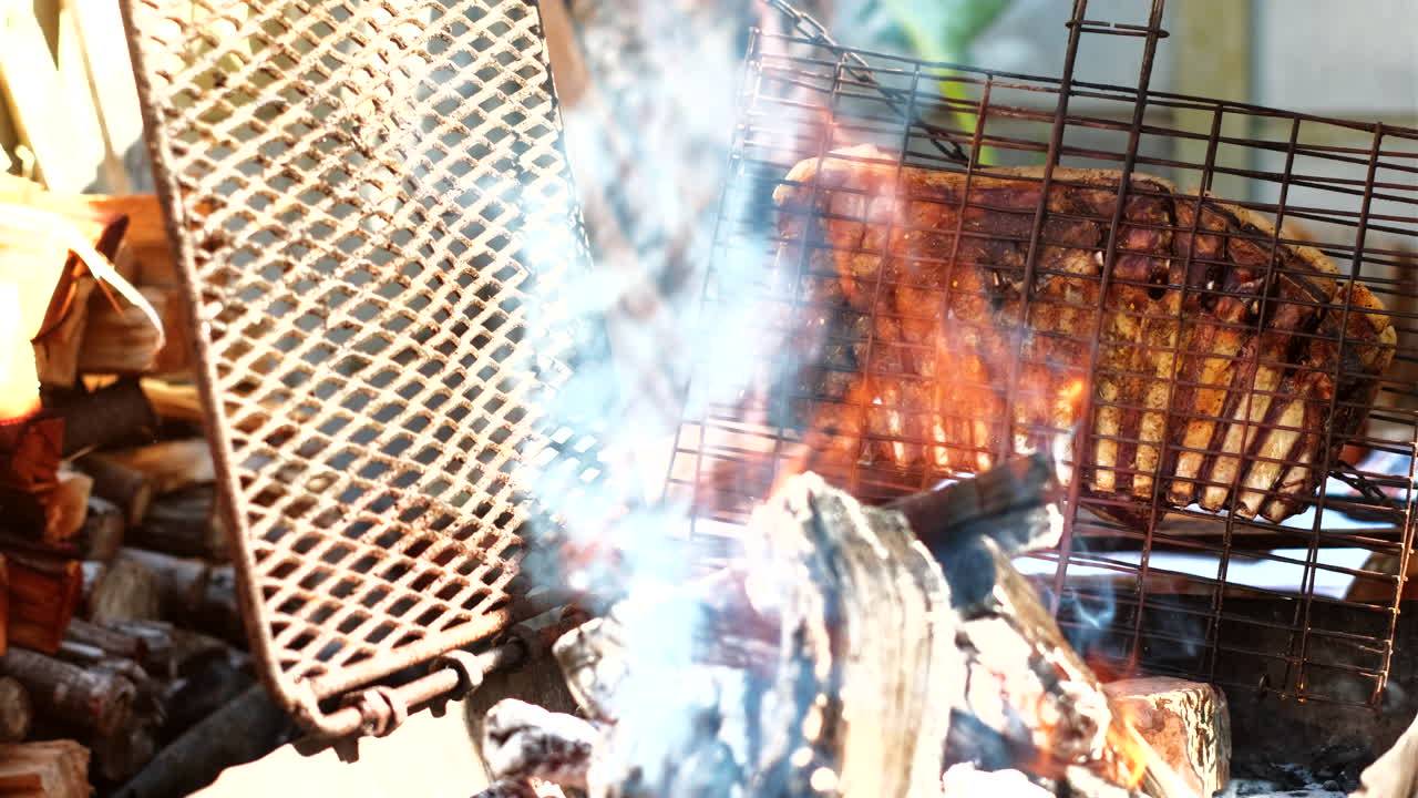 Juicy lamb rib barbecued upright on side of burning wood fire in South Africa