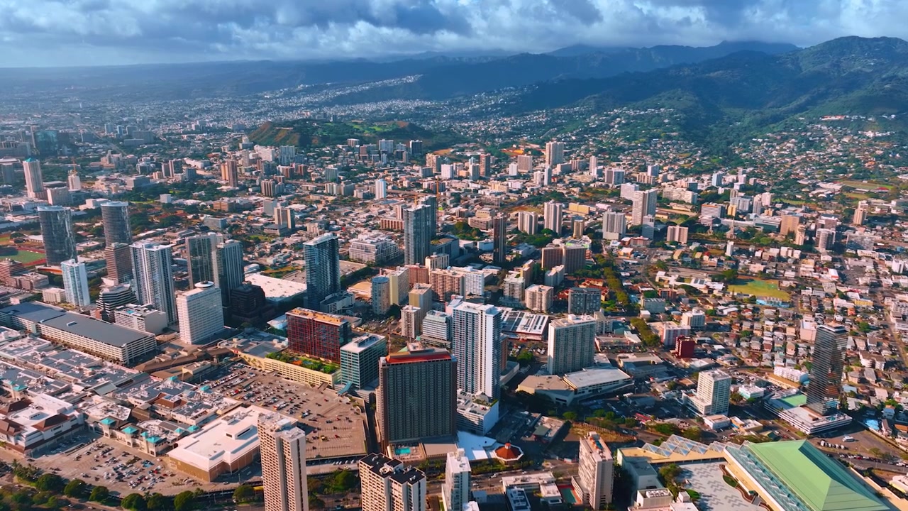 Paesaggio urbano variegato della densamente edificata Honolulu, Hawaii, USA. Prospettiva aerea sulla città sotto un cielo grigio nuvoloso