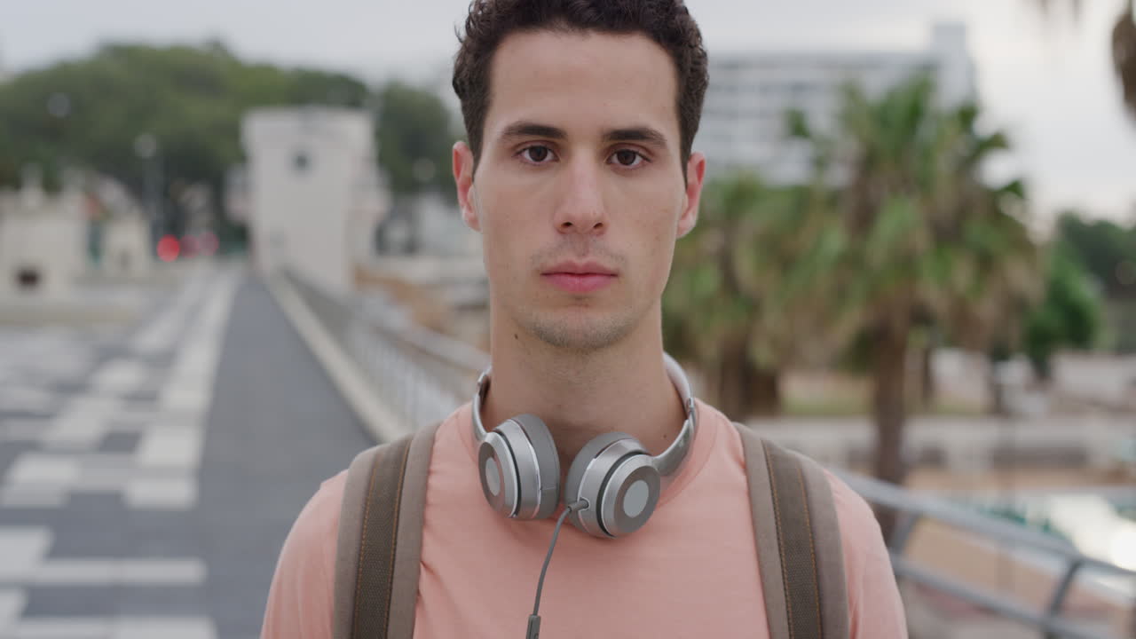retrato atractivo joven hombre hispano buscando estudiante masculino serio en el fondo de la ciudad urbana