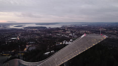 holmenkollbakken ski jumping hill at dusk with panoramic view of the city in oslo, norway