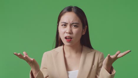 close up of asian male business woman showing puzzled gesture and saying what on green screen background