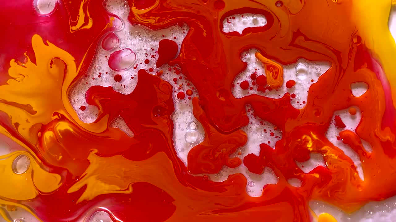 빨간색과 노란색 수채화 잉크가 물과 기름에 여 있습니다.