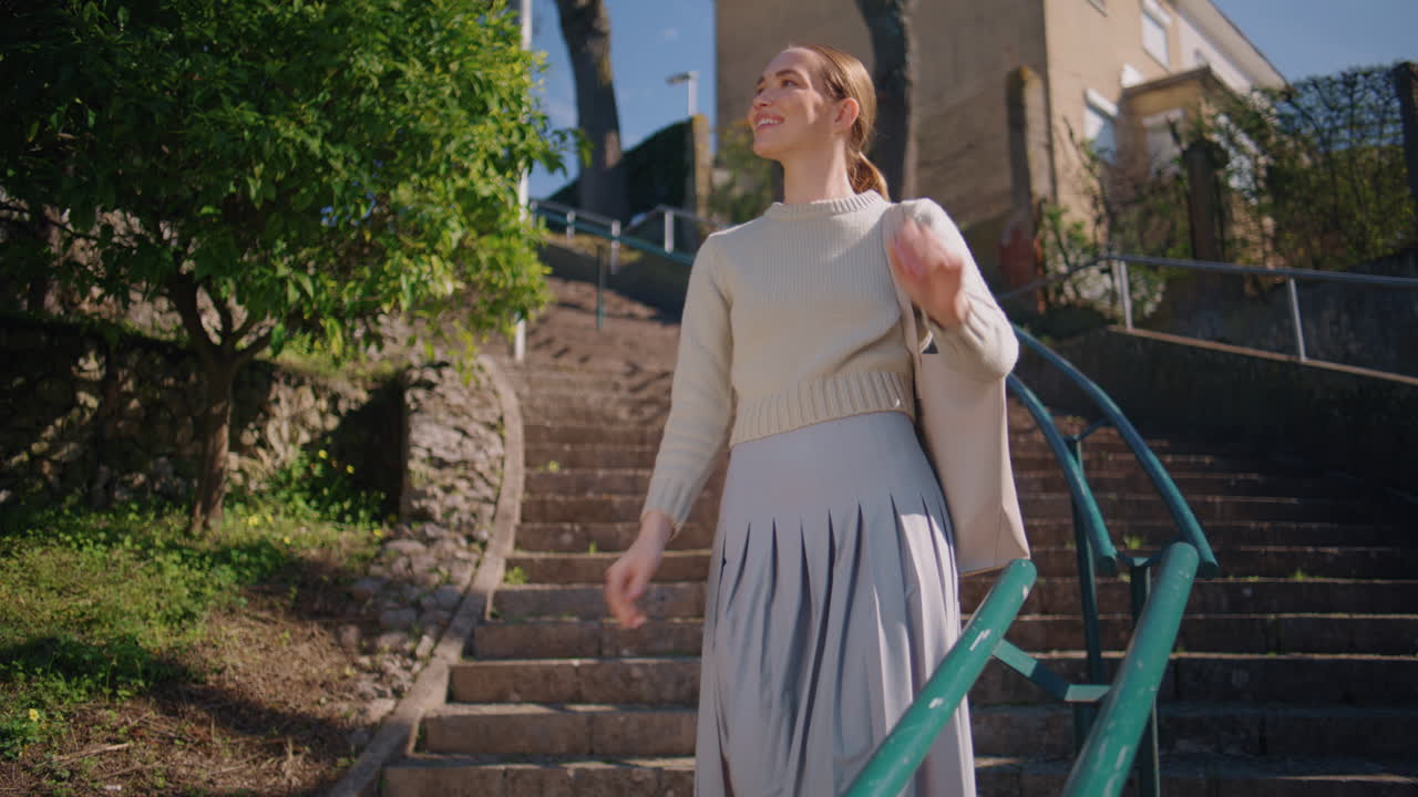 Young teacher checking notebook at sunlight staircase. Woman enjoying break