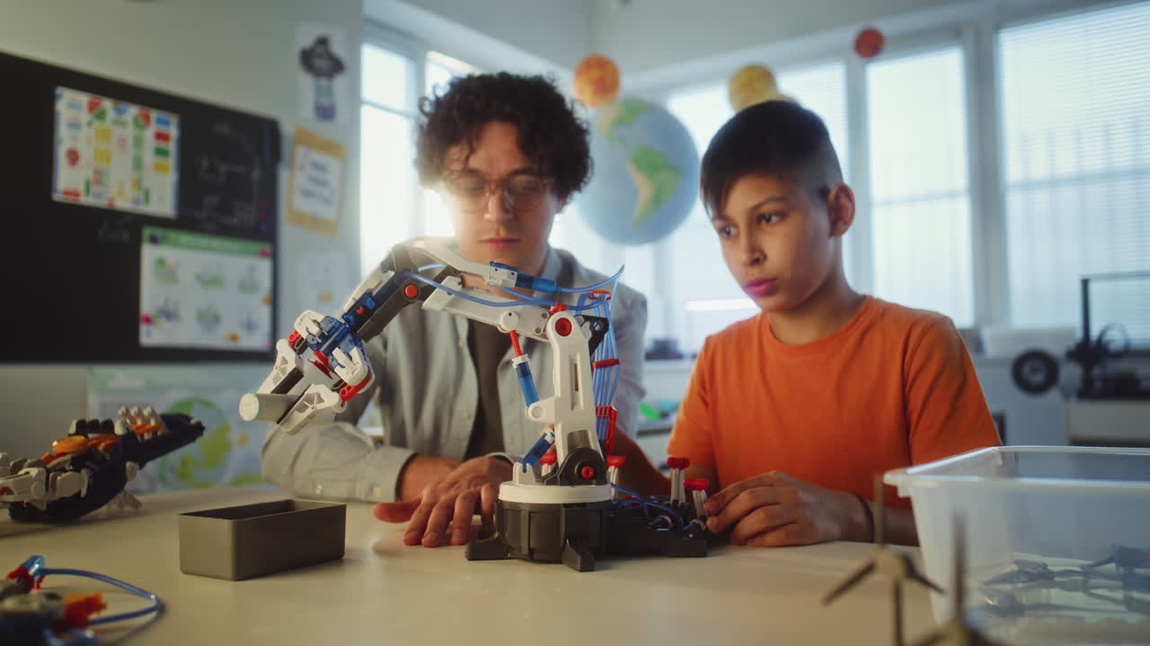Student and Teacher Working on a Robot Arm in a Classroom