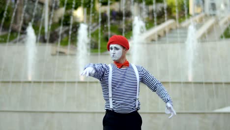 mime conductor gesticulating hands at fountain background