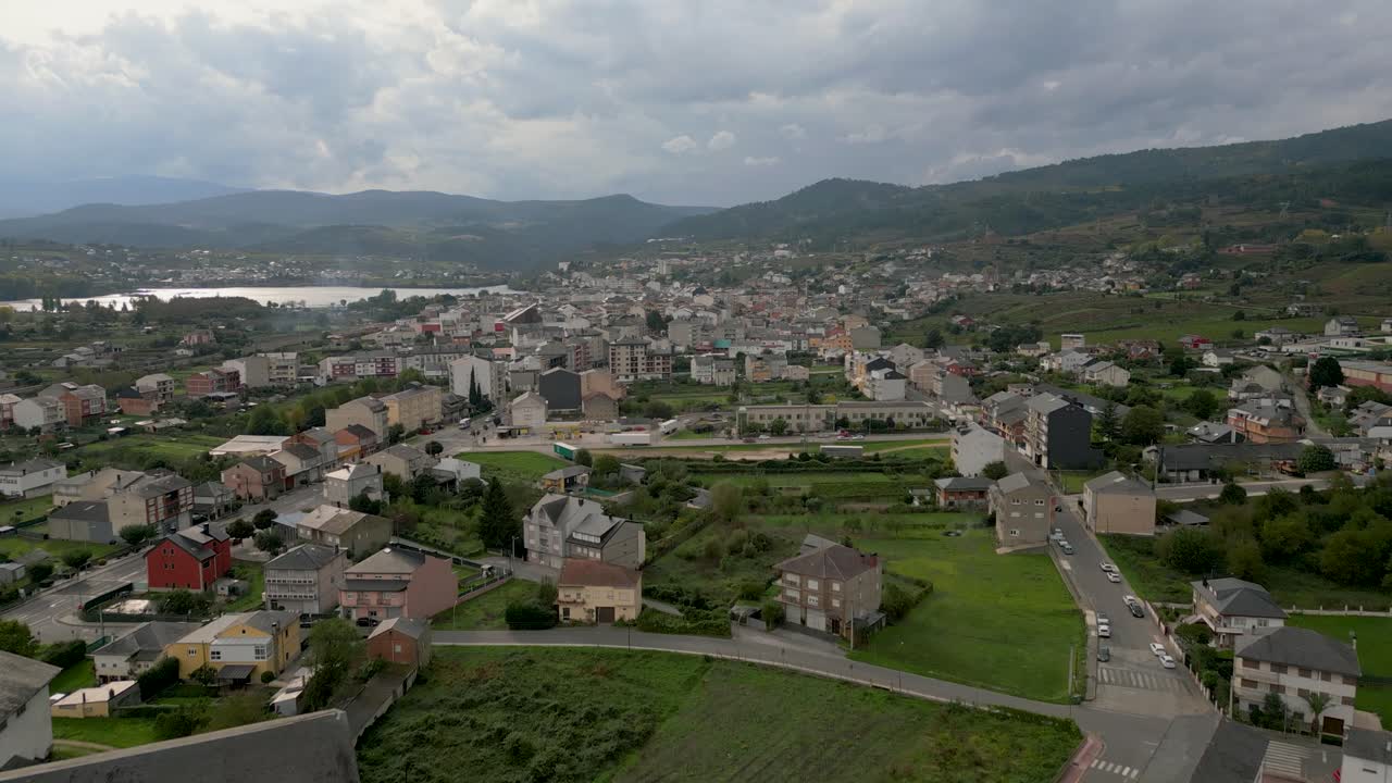 Close aerial of A Rúa, Galicia, capturing town's urban layout amid countryside and scenic backdrop