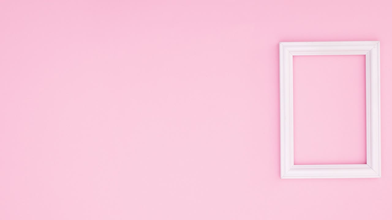 Hojas verdes aparecen en un marco blanco en el lado derecho de un tema rosa. Stop motion.