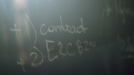 blurred image of handwritten equations on a chalkboard