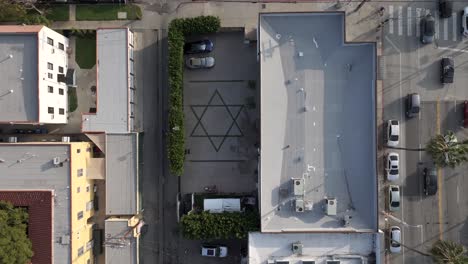 star of david, jewish religious symbol, seen from overhead on parking lot floor, aerial pull out