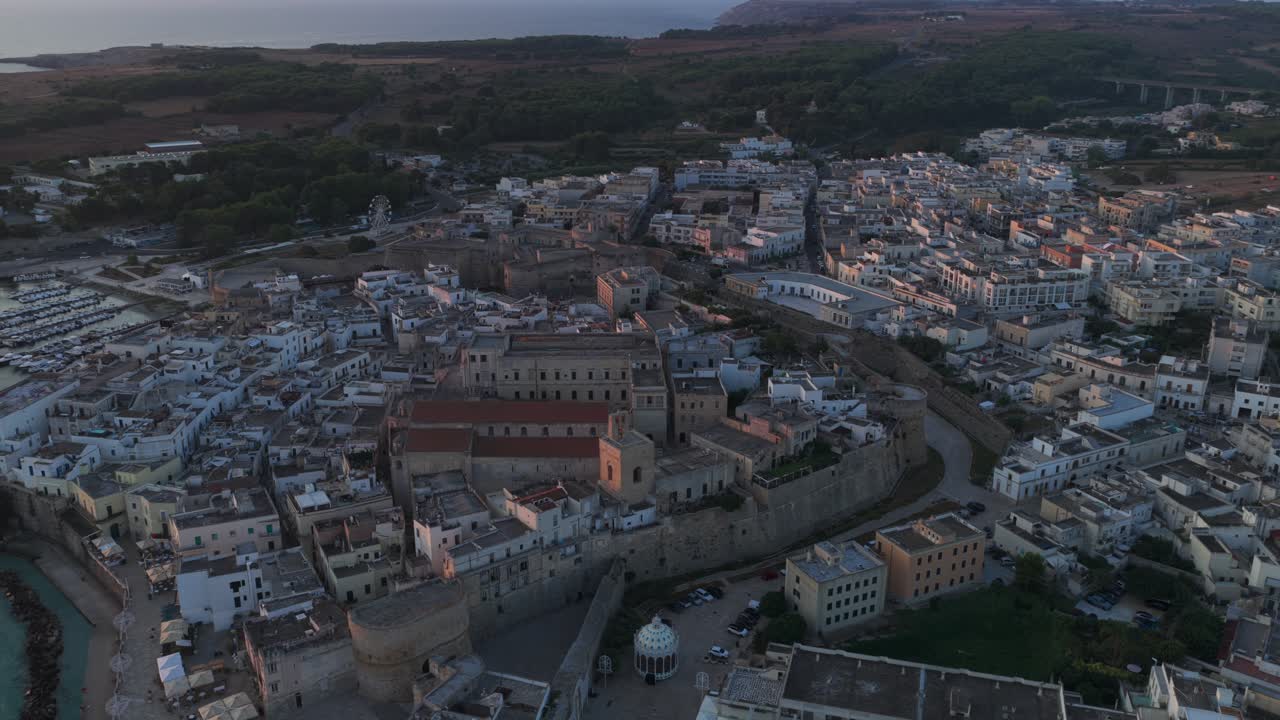 Wide sunset aerial orbit of Otranto, Italy, picturesque Italian coastal town