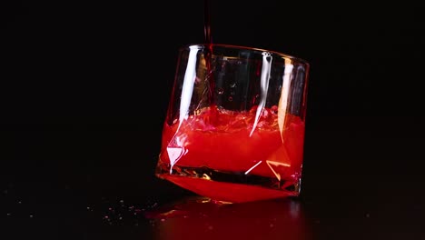 red fizzy drink poured into tilted glass