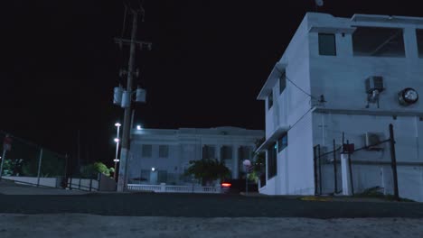 coches conduciendo entre edificios en puerto rico por la noche