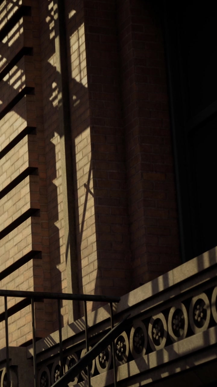 La luce del sole crea giochi di ombre sulla parete di un edificio nel tardo pomeriggio.