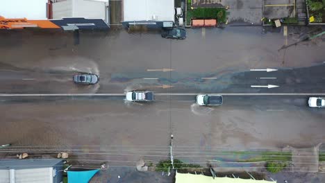 top down view of cars crossing flooded road