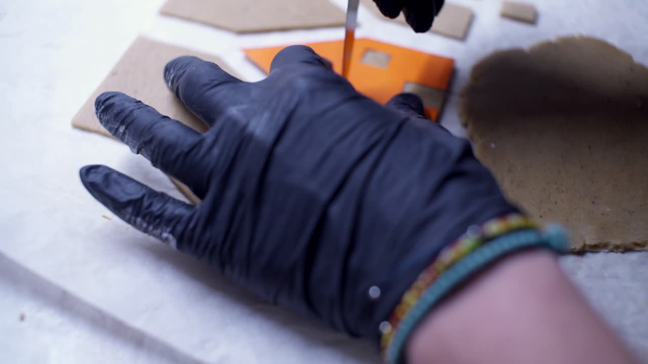 Close up on caucasian woman's hands preparing gingerbread dough, making Christmas house