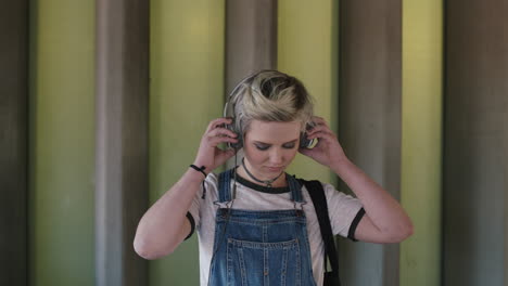 portrait-of-cool-young-woman-wearing-headphones-listening-to-music-alternative-grunge