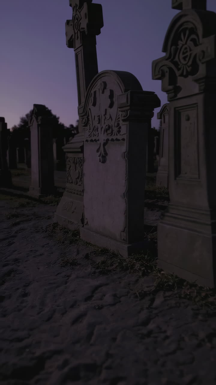 Silhouette of a Person Walking Through a Cemetery at Dusk