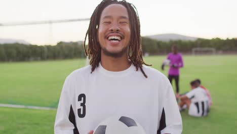 video of happy african american football player on field with ball