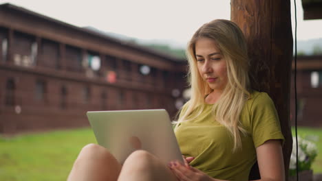 Attractive lady reads news in social media laptop on terrace
