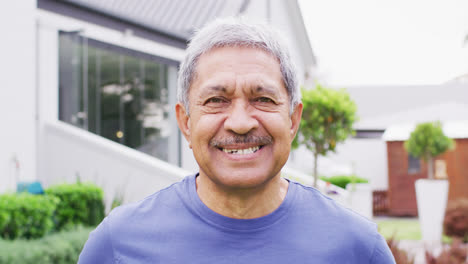 Portrait-of-happy-senior-biracial-man-looking-at-camera-in-garden