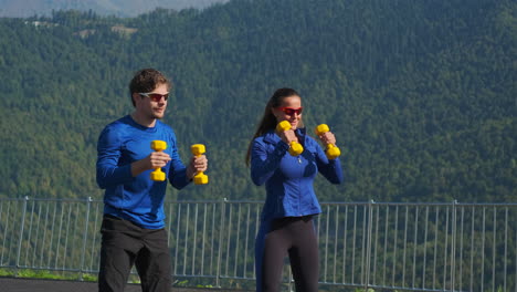pareja trabajando con pesas al aire libre