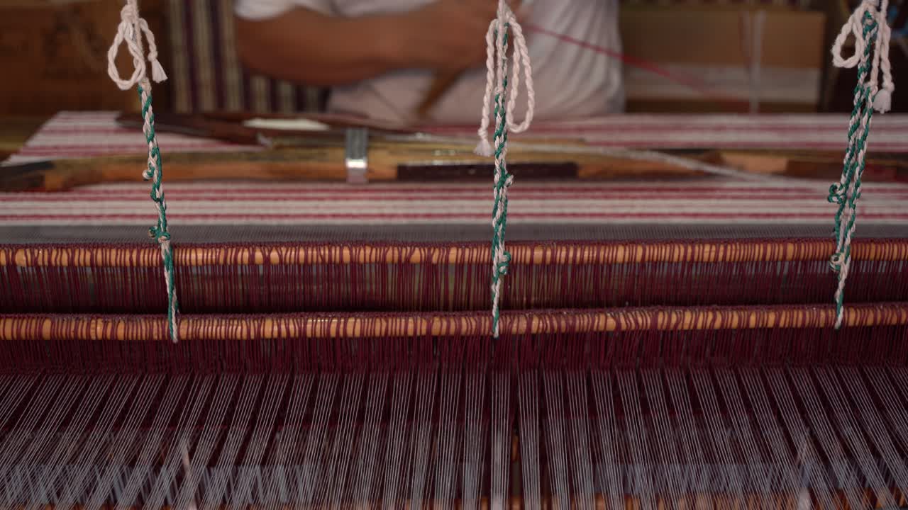 A traditional manual shuttle loom in use at a textile workshop in Morocco, showing artisan weaving technique