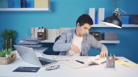 Clever-kid-studying-at-desk,-using-laptop,-taking-notes.