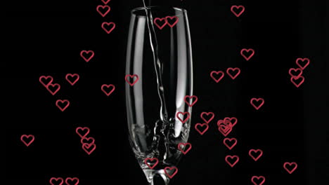 pouring liquid into glass with red hearts animation over black background