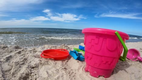 Juguetes-De-Plástico-En-La-Playa-De-Arena