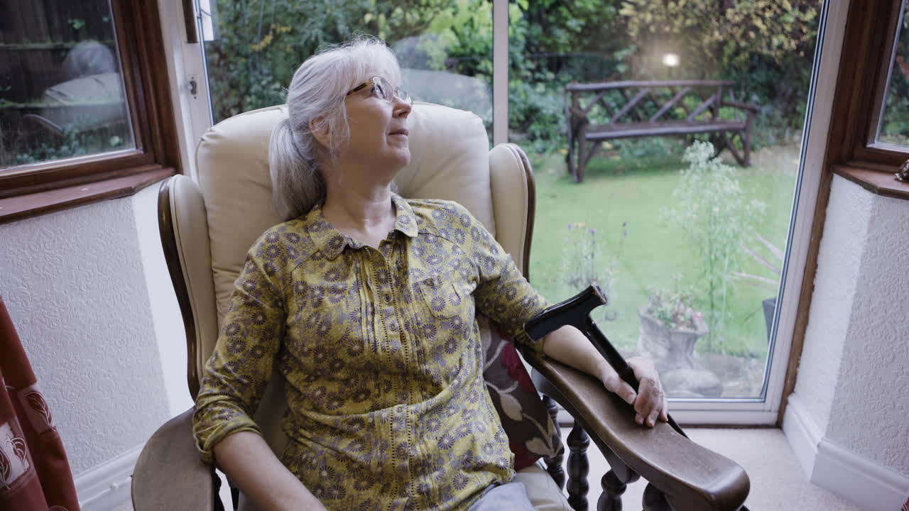 Senior woman relaxing in an armchair by the window
